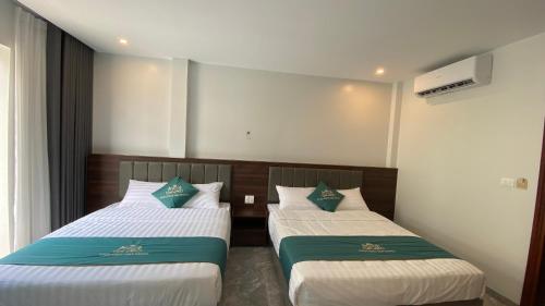two beds in a hotel room withacers at Tuần Châu HQT in Ha Long