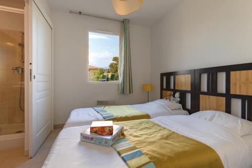 1 dormitorio con 2 camas y ventana en Lagrange Vacances Les Terrasses des Embiez, en Six-Fours-les-Plages