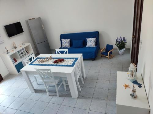 a living room with a white table and a blue couch at Porto Selvaggio Casa Zaffiro in Torre Inserraglio