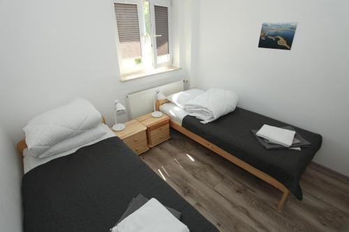 two beds in a small room with a window at Wigierski Park Narodowy in Suwałki