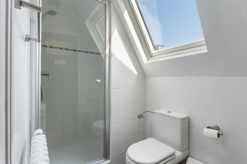 a bathroom with a toilet and a shower with a window at Les Pinsons - Familievilla met strandzicht én tuin in Knokke-Heist