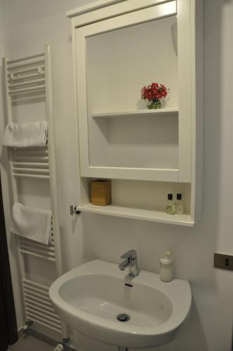 a white bathroom with a sink and a mirror at B&B Casa Soresina in Offagna