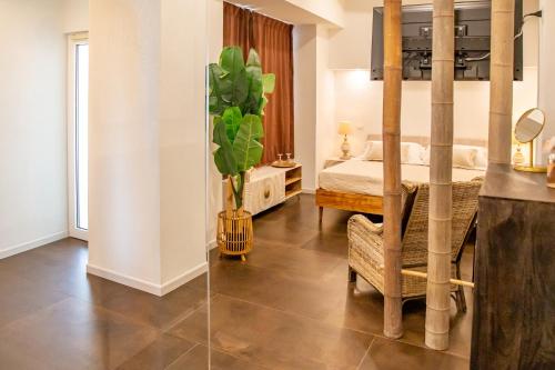 a bedroom with a bed and a plant in a room at Amelia Apts & Rooms in Alghero