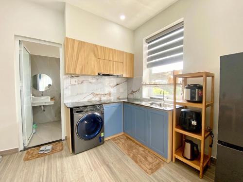 a kitchen with a washing machine and a sink at Moc Son Apartment - Attractive price for week and month stay - Serene Beachside Retreat Near Marble Mountains in Da Nang