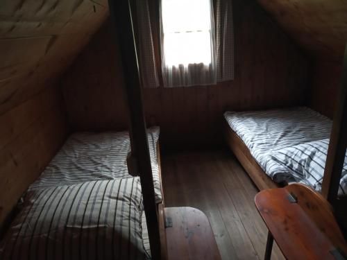 two beds in a small room with a window at Chatrč pod Babou in Křivoklát