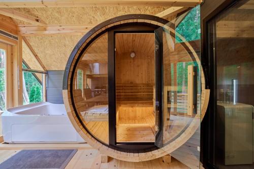 ein rundes Bad mit einer Badewanne und einem großen Spiegel in der Unterkunft GRAN TOCORO. RESORT&GLAMPING in Narusawa