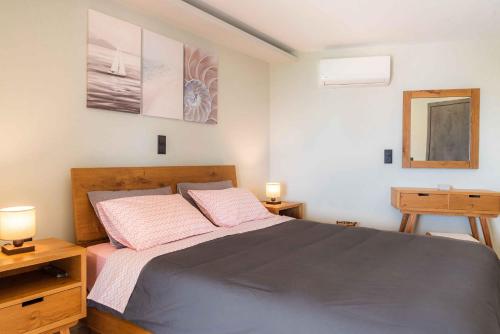 1 dormitorio con 1 cama con 2 lámparas y espejo en Ηοrizon View House, en Nótos