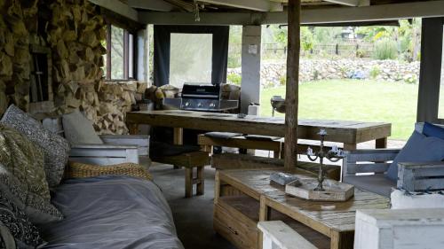 a room with a table and benches and a grill at Rainforest Ridge Eco Resort in The Crags