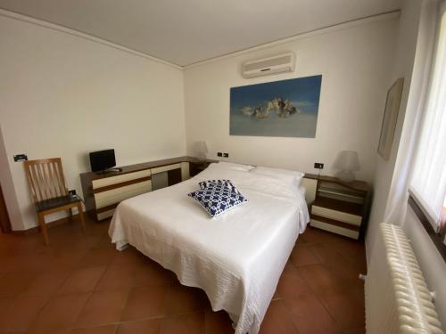 um quarto com uma cama branca e uma almofada em Ca' Rina apartment FREE PARKING LAKE VIEW em Lierna