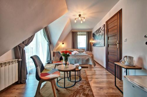 a hotel room with a bed and a table and chairs at Willa Karpinskich in Zakopane