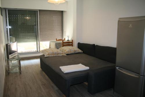 ein kleines Schlafzimmer mit einem Bett und einem großen Fenster in der Unterkunft Studio centre-ville, Terrasse, Parking in Montpellier