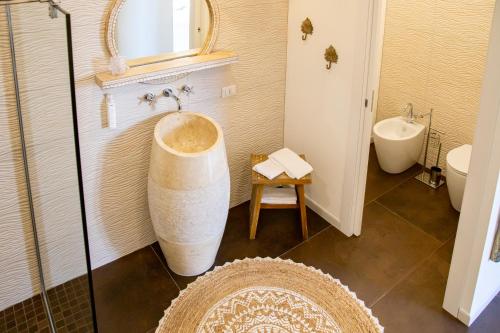 a bathroom with a tub and a sink and a toilet at Amelia Apts & Rooms in Alghero
