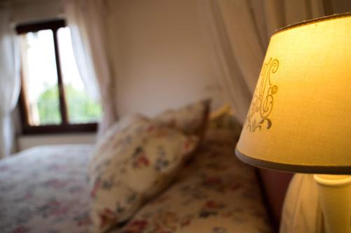 a bedroom with a bed with a lamp and a pillow at Casa Di Mi in Serrungarina