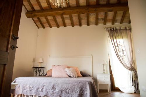 a bedroom with a bed with pink sheets and a window at Casa Di Mi in Serrungarina