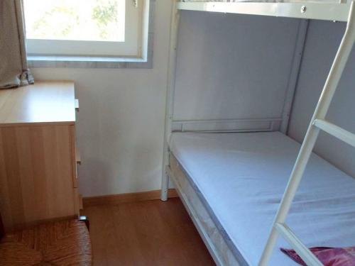 Ce lit superposé se trouve dans une petite chambre dotée d'une fenêtre. dans l'établissement Appartement 2 pièces avec loggia - 300m de la plage de Carnac - FR-1-477-91, à Carnac