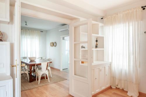 eine Küche und ein Esszimmer mit einem Tisch und einer Tür in der Unterkunft O&L Aire - Spacious and Bright Apartment in the Heart of Seville in Sevilla
