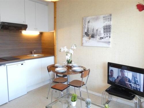 - une petite cuisine avec une table et une télévision dans la chambre dans l'établissement Studio cosy pour 4 à Saint-Lary-Soulan avec balcon au sud - FR-1-457-139, à Saint-Lary-Soulan