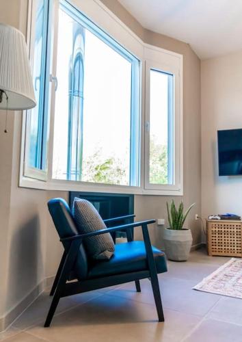 a blue chair in a room with a window at The Urban Escape in Ioannina