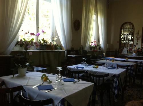 una sala da pranzo con tavoli con tovaglie bianche di Hotel Pensione Moderna a Bonassola