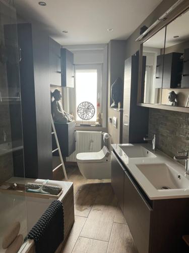 een badkamer met een wastafel, een toilet en een spiegel bij zen atitude in Sint-Martens-Lennik