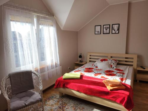 1 dormitorio con 1 cama, 1 silla y 1 ventana en Apartament Wega, en Władysławowo