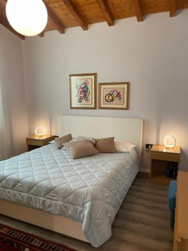 ein Schlafzimmer mit einem großen Bett mit zwei Tischen und zwei Lampen in der Unterkunft La casa in collina in Caprino Veronese