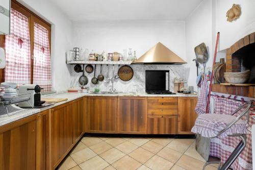 a large kitchen with wooden cabinets and a sink at La Torre in Arcola