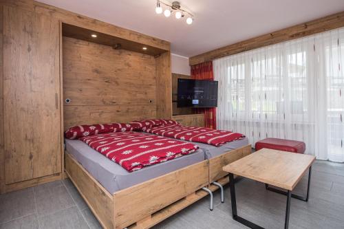 een slaapkamer met een groot bed en een houten muur bij Haus Floralp in Zermatt