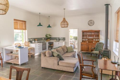 a living room with a couch and a kitchen at Huckleberry House - La Bruyere Farm in Tulbagh