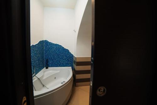 ein Badezimmer mit einer Badewanne und blauen Fliesen an der Wand in der Unterkunft Domus Gisulfo in Salerno