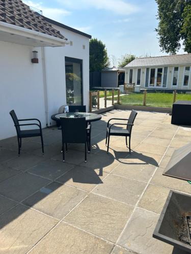 eine Terrasse mit 2 Stühlen, einem Tisch und Stühlen in der Unterkunft Lovely studio annex in Lilliput in Poole