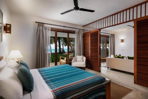 a bedroom with a bed and a living room at Lantern Boutique Hotel by Reveal in Mirissa