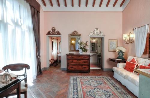 a living room with a couch and a mirror at Il Falconiere Relais & Spa in Cortona