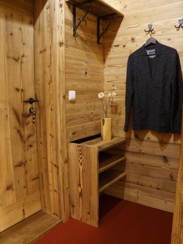 a black shirt hanging on a wooden wall in a sauna at Ferienwohnungen Bergsonne und Gipfelsonne in Bad Reichenhall