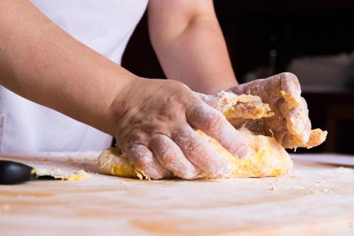 a person is kneading a piece of food on a table at Casa Di Mi in Serrungarina