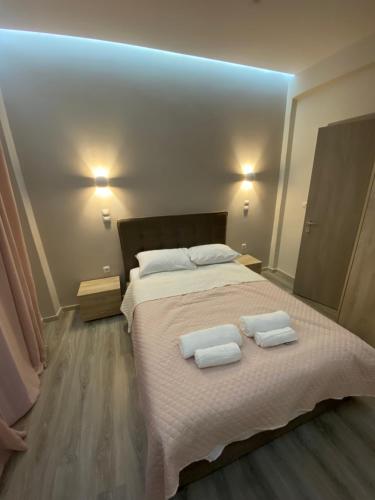 una camera da letto con un grande letto con due asciugamani di Modern Rous Apartment in Athens ad Atene