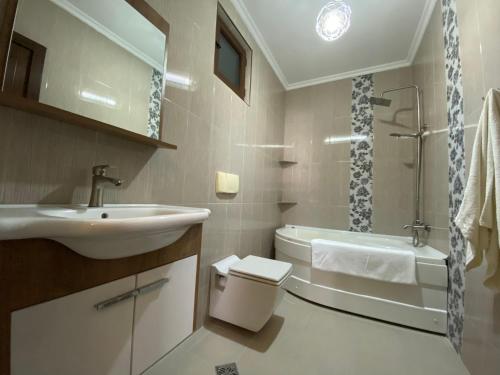 a bathroom with a sink and a toilet and a tub at Sunny Days in K'obulet'i