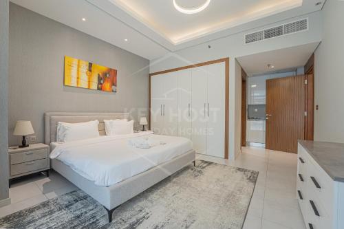 a bedroom with a large white bed in a room at KeyHost - Spacious 1BR with Parking near Five hotel in JVC - Dubai - KG10 in Dubai