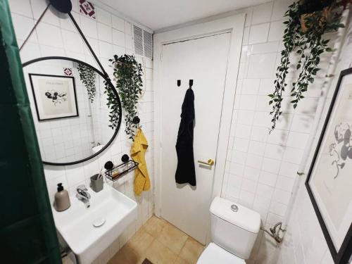 a bathroom with a sink and a toilet and a mirror at Панорамная квартира с 1 спальней в Бенидорме in Benidorm