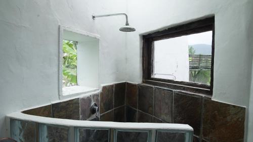 a bathroom with a window and a bath tub at Rainforest Ridge Eco Resort in The Crags