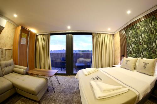 a bedroom with a bed and a couch and a window at Maranda Suit Hotel in Istanbul