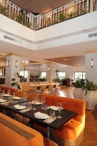 Brown Eilat a member of Brown Hotels في إيلات: غرفة طعام مع طاولات وكراسي في مطعم