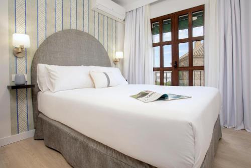 セビリアにあるGenteel Home Conde de Ibarraの窓付きの客室で、白い大型ベッド1台が備わります。