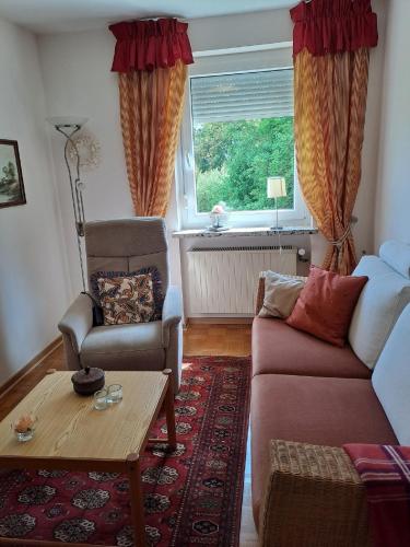 a living room with a couch and a table and a window at Ferienwohnung Am Schloss in Untermerzbach