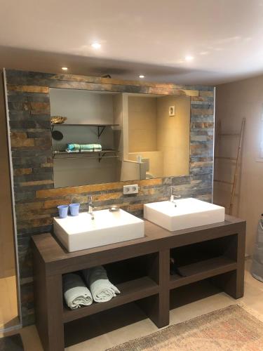 une salle de bain avec deux lavabos et un grand miroir dans l'établissement villa la source claire, à Carros