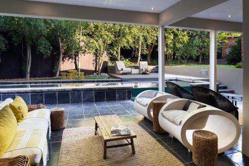 a patio with couches and a swimming pool at Alpine Attitude Boutique Hotel & Conference Venue in Pretoria