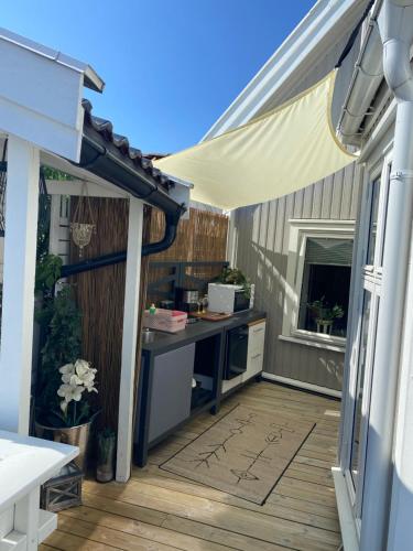 an outdoor patio with a table and a kitchen at Monas sommerresidens midt i hjertet av Kragerø in Kragerø