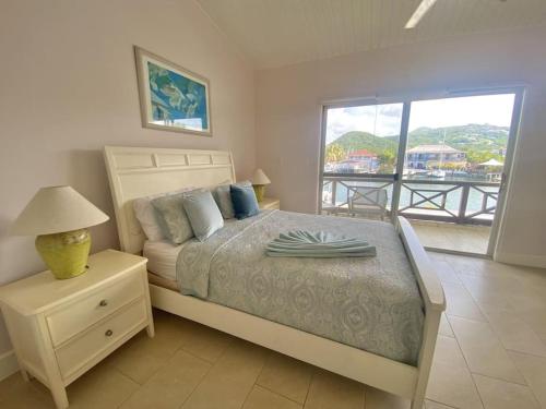 a bedroom with a bed with a view of a balcony at Villa 218G Jolly Harbour in Jolly Harbour