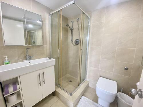 a bathroom with a shower and a toilet and a sink at Villa 218G Jolly Harbour in Jolly Harbour