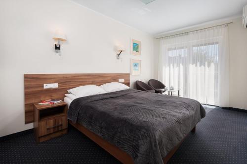 a bedroom with a large bed and two chairs at Villa Stella Baltica in Władysławowo